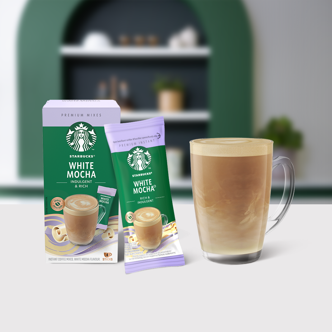 Paquet Starbucks® White Mocha Boissons Instantanées Premium à côté d'un verre à café