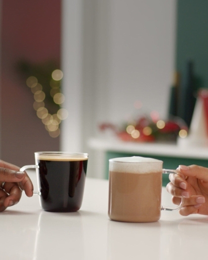Two coffees being held my two different hands