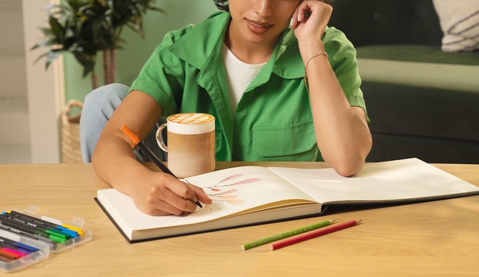 Woman drawing while enjoying slow morning coffee ritual