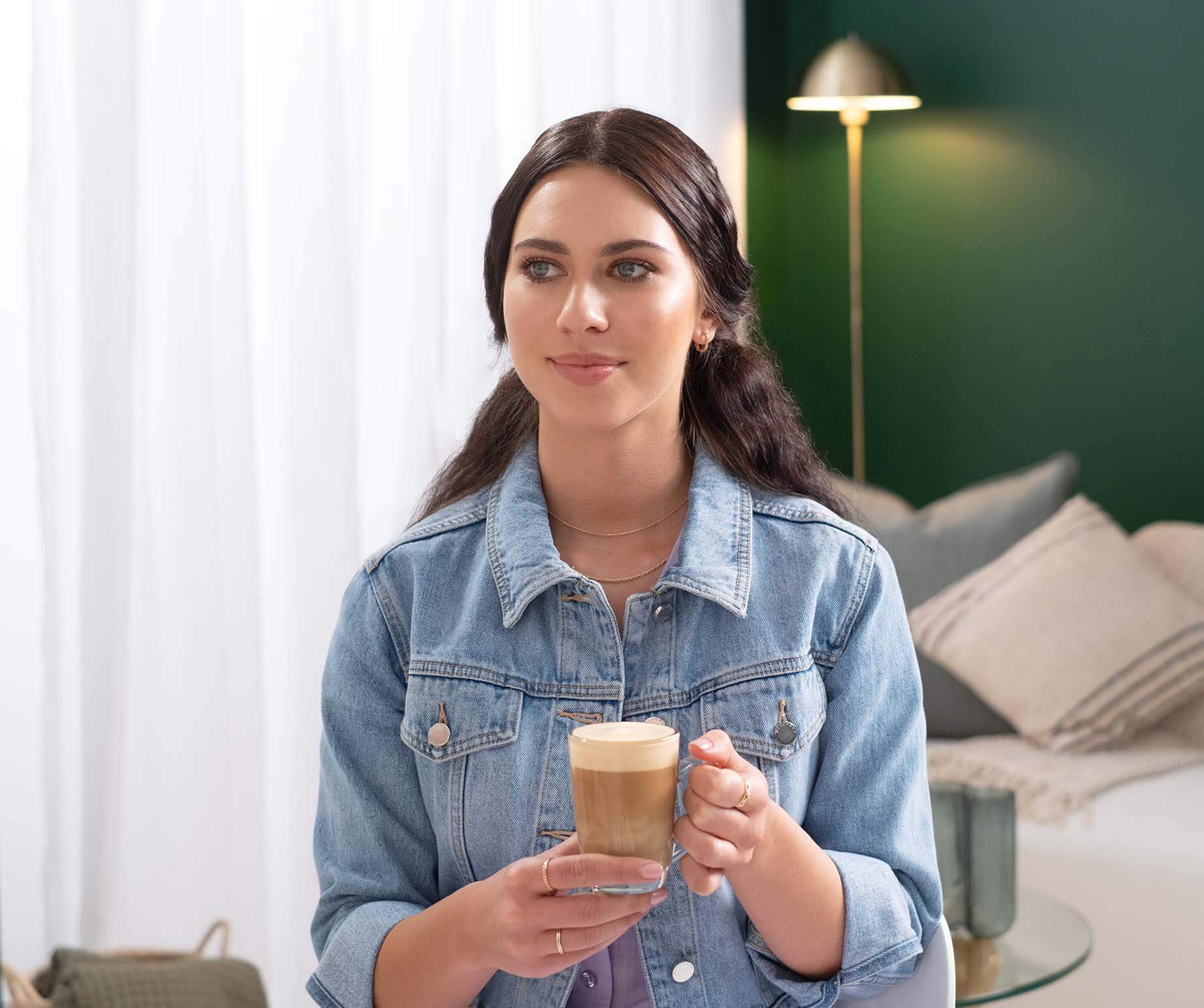 Woman enjoying Starbucks® Caramel Latte Premium Instant Coffee
