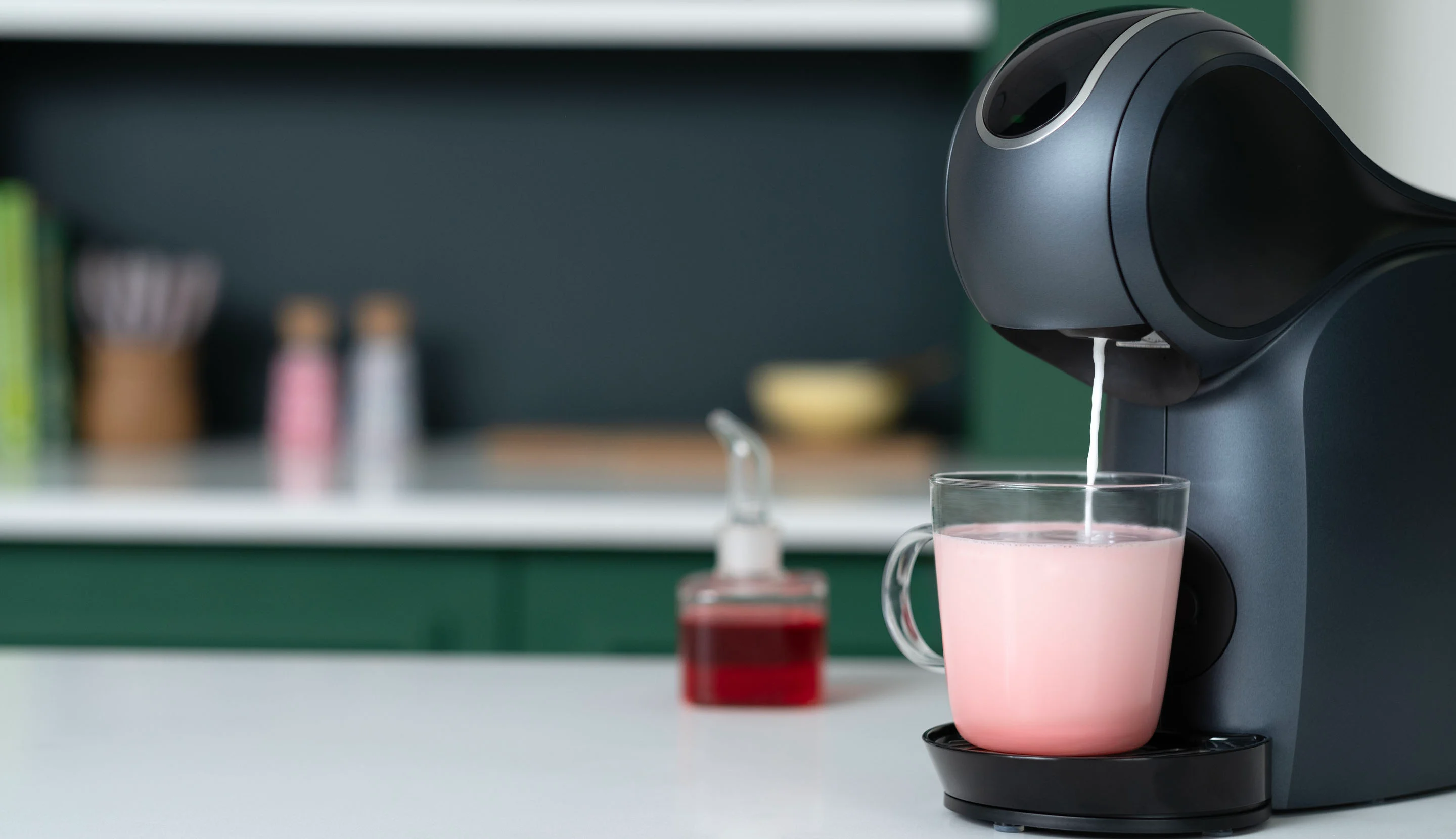 Pink milk is brewed into a mug using a NESCAFÉ® Dolce Gusto® coffee machine.