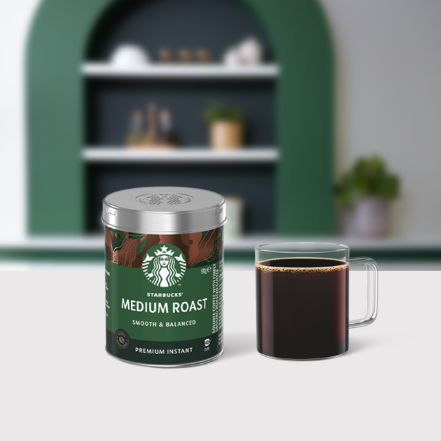 Starbucks® Premium Instant Coffee Medium Roast tin package next to a coffee glass