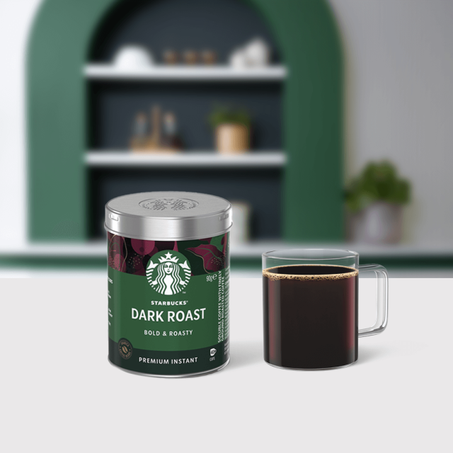 Starbucks® Premium Instant Coffee Dark Roast tin package next to a coffee glass