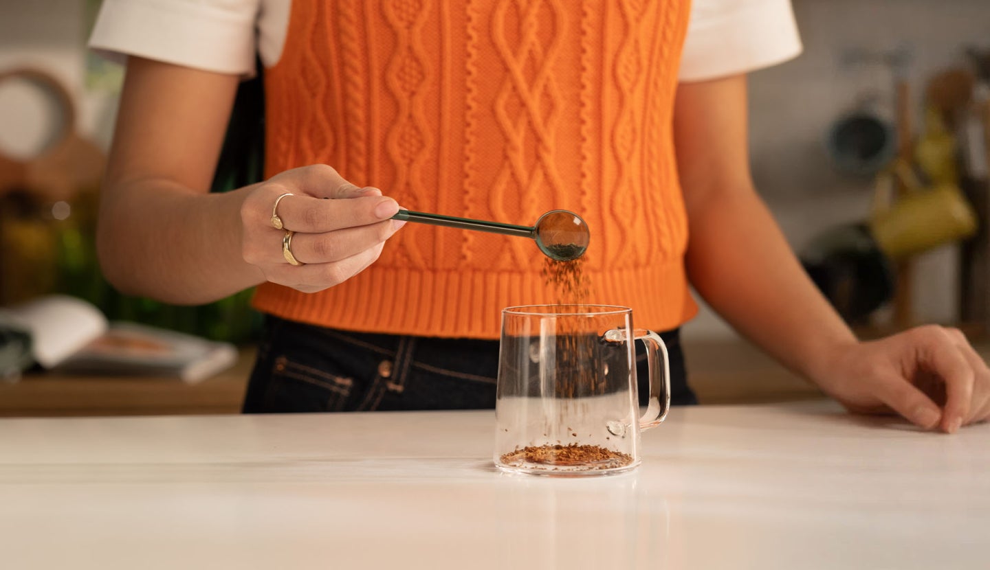 Person making soluble coffee in a glass