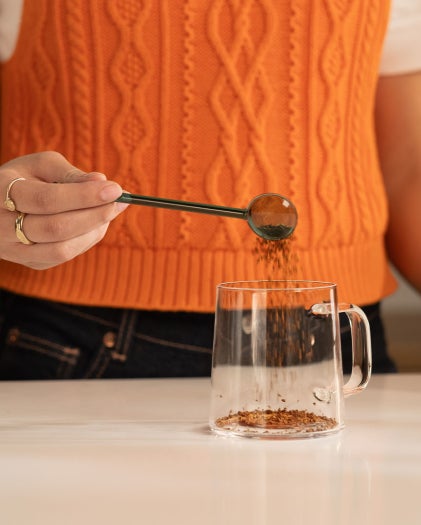 Person making soluble coffee in a glass