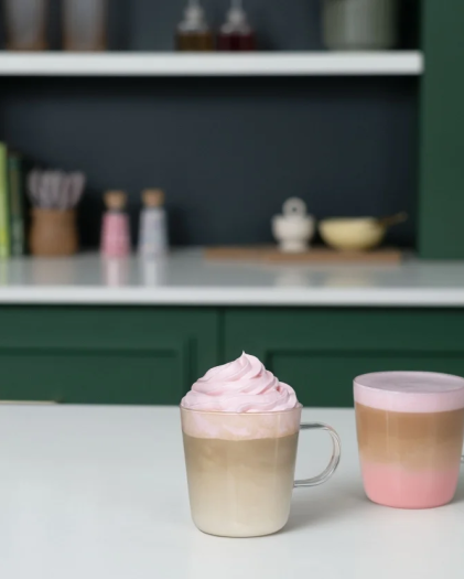 Three colourful layered coffee drinks with pink foam and sprinkles, inspiring creative coffee customisation.