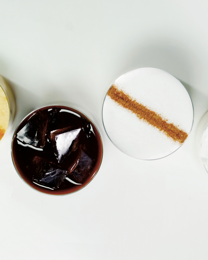Overhead view of icedStarbucks® coffees topped with cinnamon, cocoa and whipped cream.