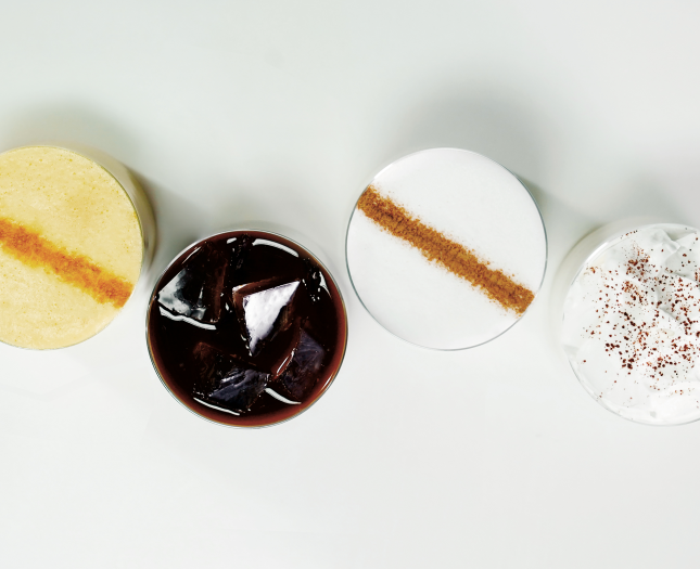 Overhead view of icedStarbucks® coffees topped with cinnamon, cocoa and whipped cream.