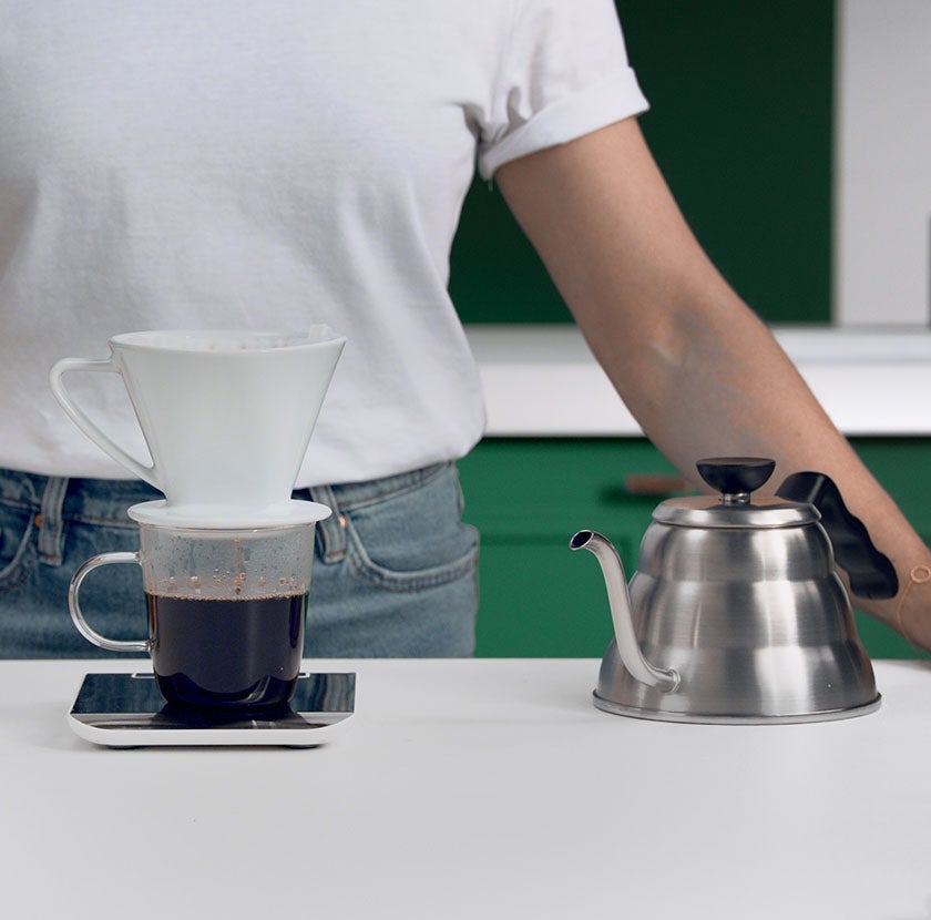 Vierta el filtro con el café molido en el embudo enfocado preparación del  café con filtro de goteo vierta el método alternativo de verter agua sobre  los granos de café tostados y